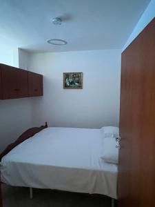 ein Schlafzimmer mit einem weißen Bett und einem Bild an der Wand in der Unterkunft The Soft Pines Escape in Golem