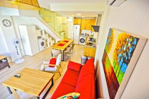 a living room with a red couch and a table at Jacuzzi & Pool House w Rooftop Terrace, Garden BBQ in El Puerto de Santa María