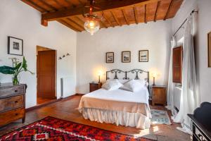 a bedroom with a large bed and a wooden ceiling at Tenuta di Corsano in Monteroni dʼArbia +156 photos