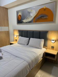 a bedroom with a bed and a painting on the wall at Pollux studio Suite 2 by Superstay in Batam Center
