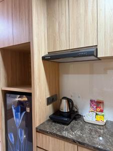 a kitchen with a stove and a tea kettle on a counter at Pollux studio Suite 2 by Superstay in Batam Center