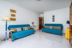 a living room with two blue couches and a lamp at Classic & Spacious Flat w/ Balcony by HostWise in Monte Gordo