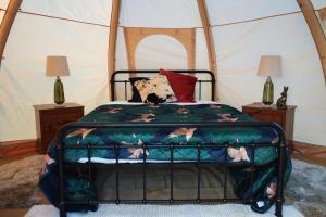 a bedroom with a bed in a tent at Knoll View Glamping Tent in Draycott