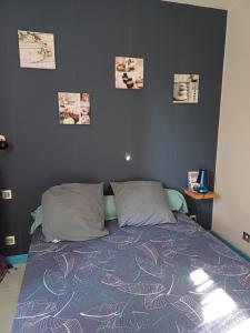 a bed in a bedroom with pictures on the wall at REVES BLEUS in Crans