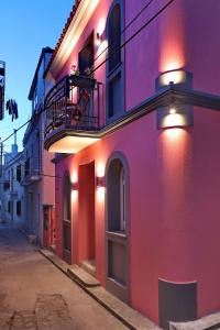 a pink building with a balcony on a street at Fouxia-Yellow in Skopelos Town