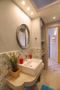 a bathroom with a white sink and a mirror at Fouxia-Yellow in Skopelos Town
