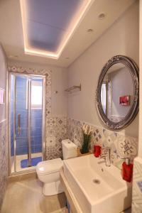a bathroom with a sink and a toilet and a mirror at Fouxia-Yellow in Skopelos Town +31 photos