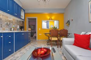 a living room with a couch and a bowl of fruit on a table at Fouxia-Yellow in Skopelos Town