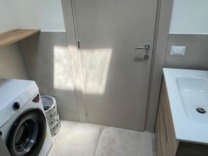 a bathroom with a washing machine and a sink at Cori di Capreria in Marina di Palma