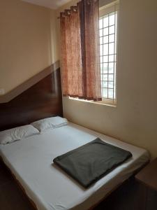 a bed in a small room with a window at TKS Residency in Bengaluru +2 photos