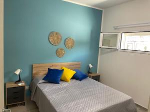 a blue bedroom with a bed with blue and yellow pillows at Cori di Capreria in Marina di Palma