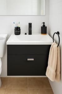 a bathroom with a black and white sink at Chalet con pileta y quincho, hermoso jardín in Tandil