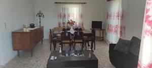 Una sala de estar con una mesa y un comedor. en Alexandros Home, en Perdika