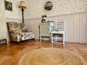 a living room with a chair and a table at El RINCÓN DE LAS PARRAS in Las Parras de Martín