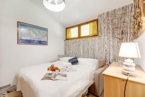 a bedroom with a bed and a table with a lamp at Appartamento Alpine Inspiration - Happy Rentals in Cesana Torinese