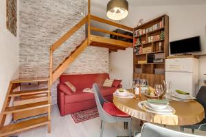 un salon avec une table et un canapé rouge dans l'établissement Appartamento Alpine Inspiration - Happy Rentals, à Césane 19 autres photos