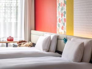 a hotel room with two beds with white pillows at Mitsui Garden Hotel Kyoto Shijo in Kyoto
