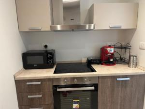 a small kitchen with a stove and a microwave at G cribs cozy 1bd apartment in El Gouna