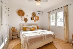 a white bedroom with a bed and a window at Casa la Flor, villa with seaview in region Malaga in Sayalonga +32 photos