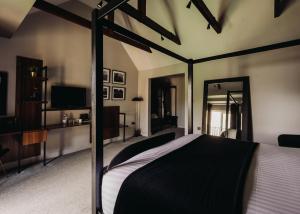 a bedroom with a large bed and a television at The Chesterton Hotel in Bicester +77 photos