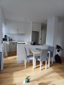 a white kitchen with a white table and chairs at Azure Escape Azores in Arrifes