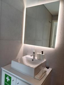 a bathroom with a white sink and a mirror at Azure Escape Azores in Arrifes +17 photos