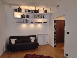 ein Wohnzimmer mit einer schwarzen Couch und Büchern in der Unterkunft Tanner's Apartment - Piramide in Rom