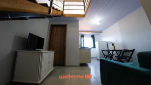 a living room with a television and a dining room at Loft no Centro de Ponta Grossa com Mezanino in Ponta Grossa