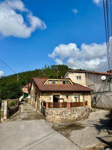 an old stone house on the side of a road at El Refugio de los Corrales in San Mateo