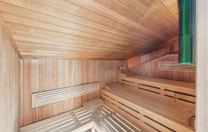 a wooden sauna with wooden floors and a green curtain at Strandblick 27 in Schönhagen