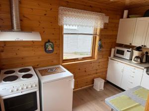 a kitchen with a stove and a white appliance at Søndre Forøya Gård in Tromsø