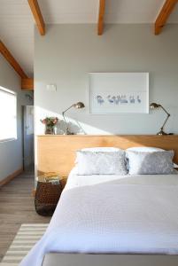 Un dormitorio con una gran cama blanca con dos almohadas. en Seehuis, en Yzerfontein
