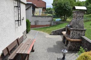 a wooden bench next to a building with a stone fireplace at Domček pod Kalváriou in Ružomberok
