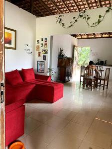 a living room with a red couch and a table at Casa na floresta cósmica in Ananindeua