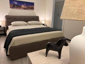 a bedroom with a large bed and a black chair at Agata dreams apartment in Catania