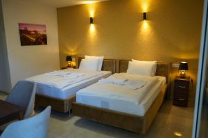 2 Betten in einem Hotelzimmer mit Wandbeleuchtung in der Unterkunft InterPension in Garbsen