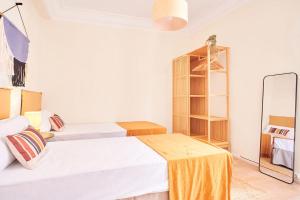 a white bedroom with two beds and a table at The Nest - by Wehomes in Santander