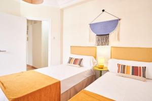 a bedroom with two beds and a lamp and a mirror at The Nest - by Wehomes in Santander
