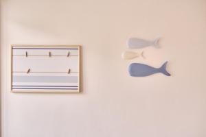a picture hanging on a white wall with two butterflies at The Nest - by Wehomes in Santander