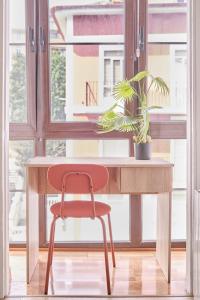 a desk with a red chair in front of a window at The Nest - by Wehomes in Santander