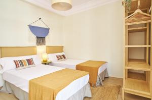 two beds in a room with white walls at The Nest - by Wehomes in Santander