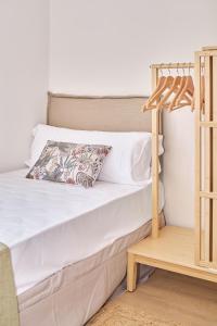 a bed with white sheets and a pillow on it at The Nest - by Wehomes in Santander