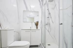 a white bathroom with a shower and a toilet at The Nest - by Wehomes in Santander +37 photos