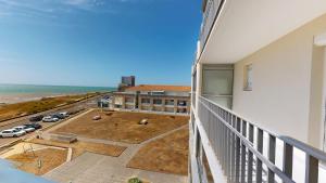 un balcón con vistas a un aparcamiento y al océano en Cap a L Ouest, en Les Bussolleries