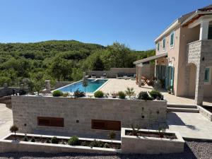 a house with a swimming pool in front of it at Villa Maluso in Budva