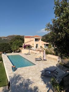 a villa with a swimming pool and a house at Casa a Scopa in Lumio