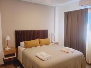 een slaapkamer met een bed met twee handdoeken erop bij Apart Hotel Concepcion in Concepción