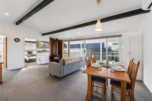 a living room with a dining table and a couch at The Cozy Corner - Taupo Holiday Home in Taupo