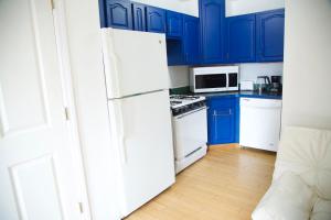 a kitchen with blue cabinets and a white refrigerator at x 3blue2934 in Brooklyn