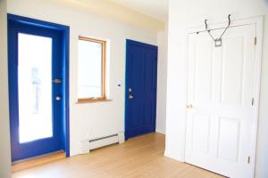 a room with two blue doors and a wooden floor at x 3blue2934 in Brooklyn +4 photos